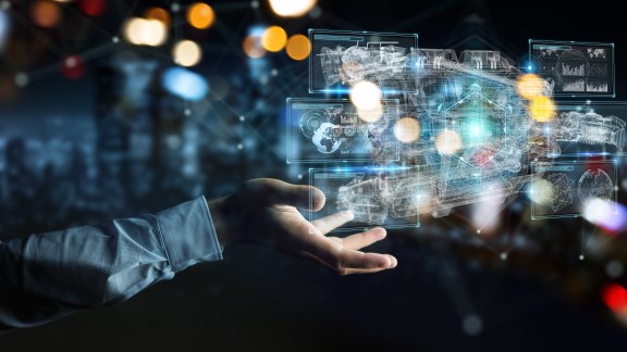 Businessman on blurred background using wireframe holographic 3D digital projection of an engine